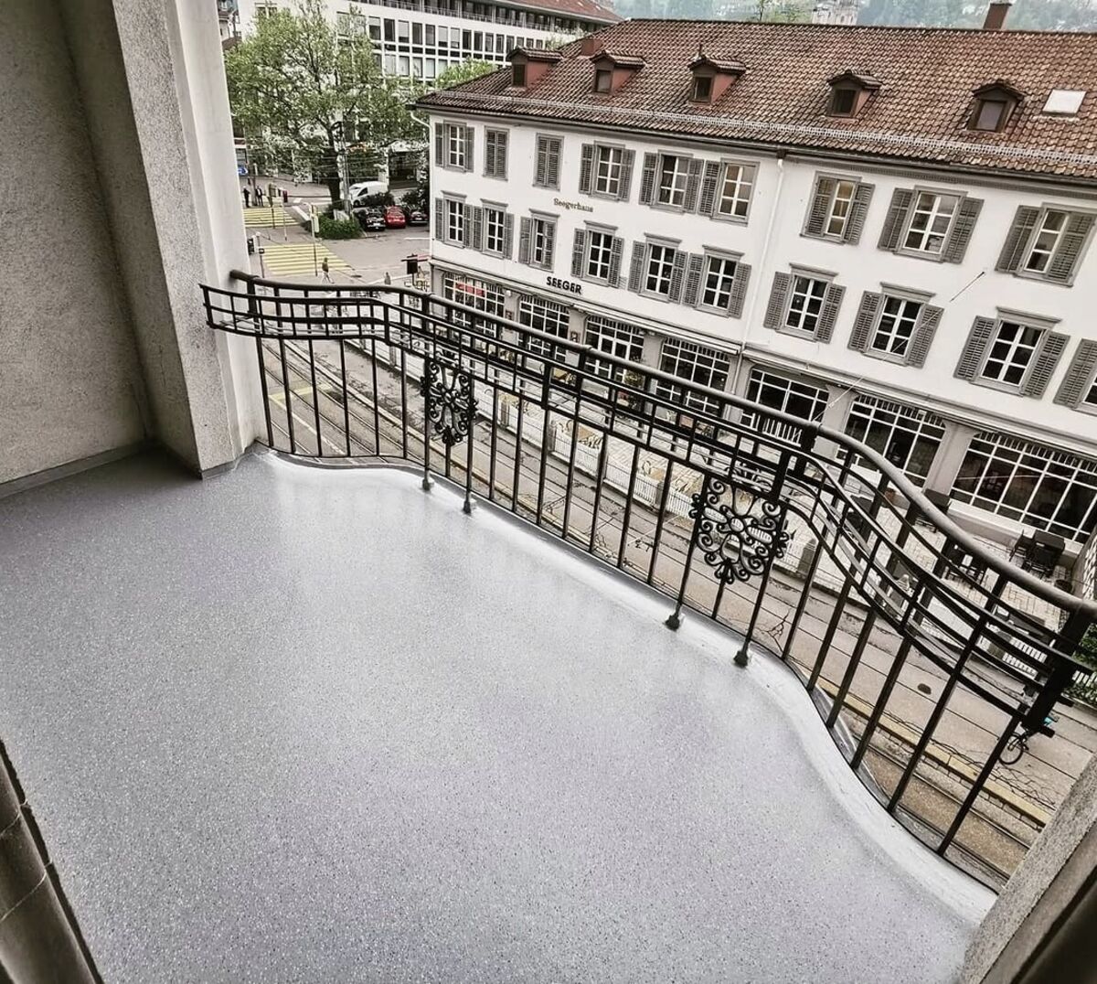 Balkon nach der Sanierung, gesprenkelte Beschichtung mit Stadtblick